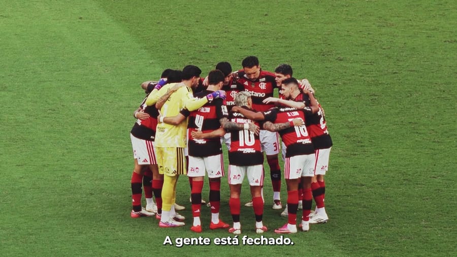 Jogadores do Flamengo reunidos em círculo no gramado, com a frase: a gente está fechado
