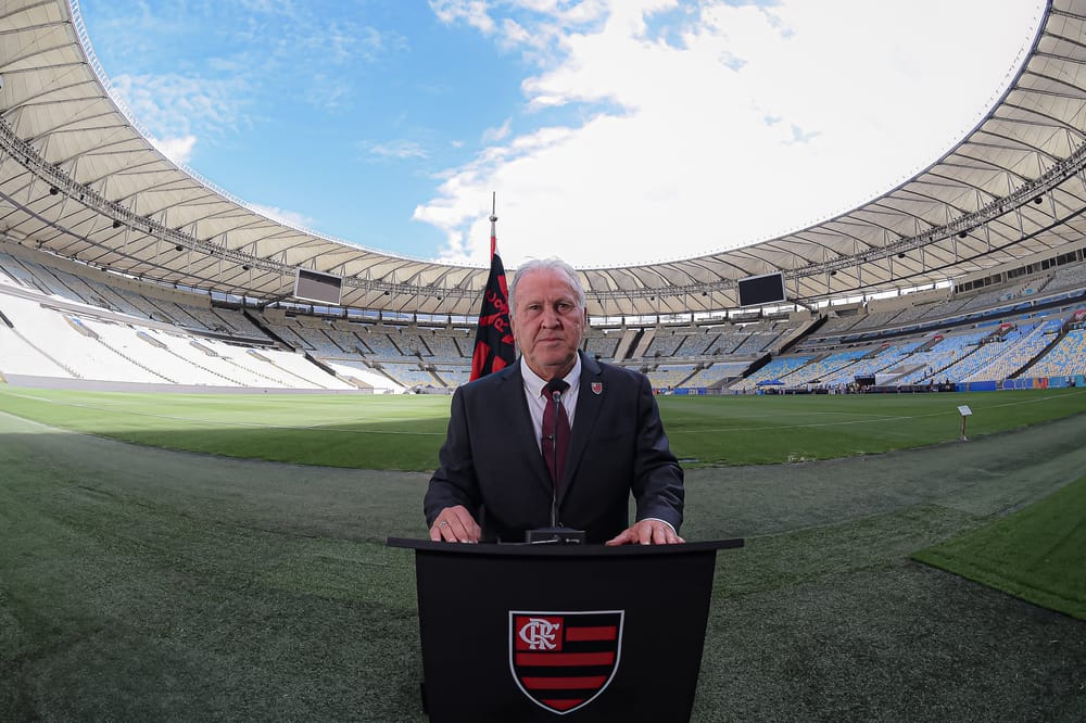 Zico discursa no púlpito, no gramado do Maracanã, com a bandeira da campanha Nação na ONU ao fundo
